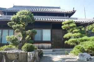 a house with a tree in front of it at 民泊 桔梗 in Awaji