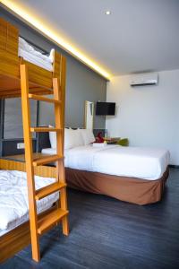 HOTEL PANTES SIMPANG LIMA SEMARANG في سيمارانغ: غرفة نوم بسريرين بطابقين وسلم
