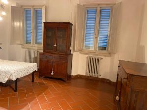 a bedroom with a dresser and a cabinet and windows at Fiesolana 26 in Florence