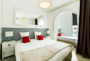 a bedroom with two beds with red pillows at Florella République Apartment in Cannes +53 photos