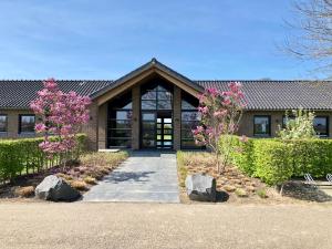 een huis met roze bloemen ervoor bij Safaritent Mini Lodge in Kesteren