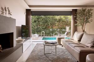 a living room with a couch and a tv and a pool at Elaia Luxury Condo Glyfada in Athens