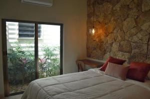 メリダにあるCASA LÁZARO- Hermosa casa familiarのベッドと石の壁のある寝室 +21枚の写真