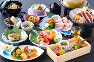 una mesa con muchos platos de comida. en Yamashiro Onsen Miyabi no Yado Kaga Hyakumangoku, en Kaga