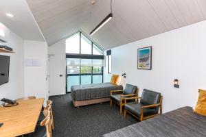 a room with two beds and a desk and chairs at The Strand in New Plymouth