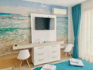a room with a desk with a television and the ocean at Studio in Diamond Beach in Burgas