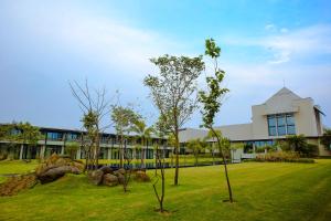 een gebouw met bomen in het gras ervoor bij Tiger Palace Resort in Bhairāhawā