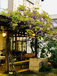 een boom met paarse bloemen voor een gebouw bij May的家民宿 in Suao