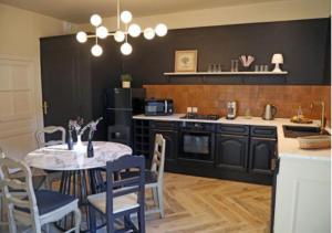 a kitchen with a table and chairs and a kitchen with a stove at Maison d'hôtes La Bella Casa in Villette-dʼAnthon