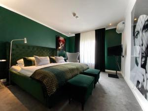 1 dormitorio con 1 cama grande y paredes verdes en Parkhotel Bielefeld, en Bielefeld