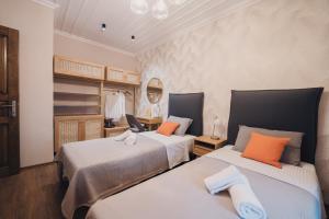 a bedroom with two beds with orange pillows at Elia City House in Kavala