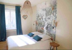 a bedroom with a white bed with blue pillows at Maison d'hôtes La Bella Casa in Villette-dʼAnthon