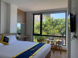 sypialnia z łóżkiem i dużym oknem w obiekcie VISION HOTEL w mieście Phan Rang-Tháp Chàm
