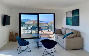 a living room with a couch and a table and chairs at Résidence Storia d'Estate in LʼÎle-Rousse