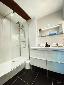 a white bathroom with a shower and a sink at L'AccrocheCoeur in Saint Malo