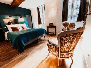 a bedroom with a bed and a chair at L'AccrocheCoeur in Saint Malo