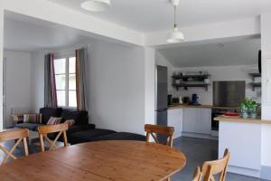 a kitchen and a living room with a wooden table at Villa avec piscine 12 personnes #0606 in Capbreton