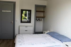 1 dormitorio con cama, espejo y ventana en Villa avec piscine 12 personnes #0606 en Capbreton