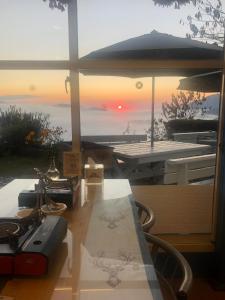 a view of the sunset from a table with an umbrella at Cingjing Brilliant Twins of Seattle in Ren'ai