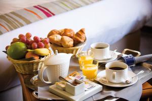 ein Tablett mit Frühstückslebensmitteln und Kaffee auf dem Tisch in der Unterkunft Holiday Inn Paris Montmartre, an IHG Hotel in Paris