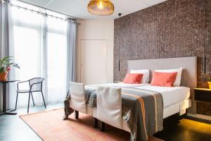 a bedroom with a bed and a brick wall at Hotel Pannenkoekhuis Vierwegen in Domburg