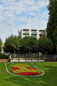 un jardín con flores frente a un edificio en H+ Hotel Bad Soden, en Bad Soden am Taunus