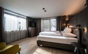 ein Hotelzimmer mit zwei Betten und einem Fernseher in der Unterkunft Plan Murin - Authentic Dolomites Hotel in Wengen + 83 Fotos