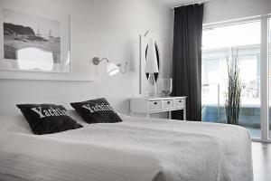 una camera bianca con un grande letto con due cuscini di Hotell Kungshamn Suites a Kungshamn