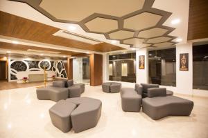 a lobby with couches and chairs and a ceiling at Lee-Benz ARK HOTEL in Kumbakonam