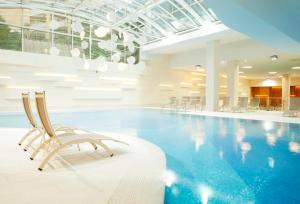 uma piscina com cadeiras num edifício em Wellness Hotel Apollo – Terme & Wellness LifeClass em Portorož