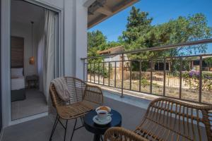 a balcony with chairs and a table with a cup of coffee at Anemelia Luxury Apartments in Argostoli