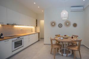a kitchen with a table with chairs and a dining room at Anemelia Luxury Apartments in Argostoli