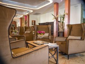 a salon with chairs and a glass of wine on a table at Hotel Terme Milano in Abano Terme