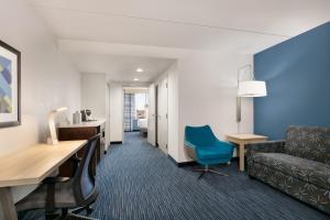 a hotel room with a couch and a chair at Holiday Inn Express Hotel & Suites Norfolk Airport, an IHG Hotel in Norfolk