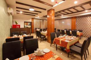 a restaurant with tables and chairs in a room at Park Residency in Kozhikode