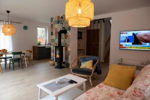 a living room with a couch and a tv at Home by the sea SASINO in Sasino