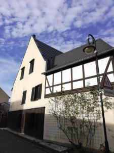 a white building with a black roof and a street light at Präsenzhof Lay in Lay