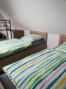 a bedroom with two beds with a colorful striped blanket at Präsenzhof Lay in Lay