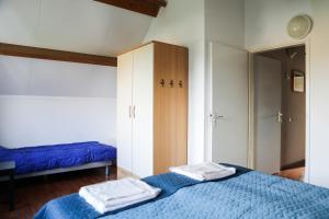 een slaapkamer met een blauw bed met 2 handdoeken erop bij Vakantiewoning 114 in villapark de oesterbaai in Wemeldinge
