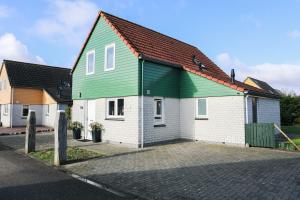een huis met een groen dak op een straat bij Vakantiewoning 114 in villapark de oesterbaai in Wemeldinge