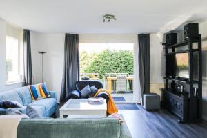 a living room with a couch and a table at Vakantiewoning 114 in villapark de oesterbaai in Wemeldinge