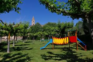 einen Spielplatz mit Rutsche in einem Park in der Unterkunft Monestir de Les Avellanes in Os de Balaguer