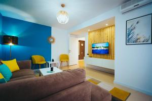 sala de estar con sofá marrón y pared azul en Vero Holiday Apartment, en Mahmudia