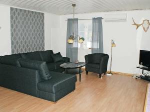 a living room with a couch and a table at Two-Bedroom Holiday home in Håcksvik 2 in Håcksvik