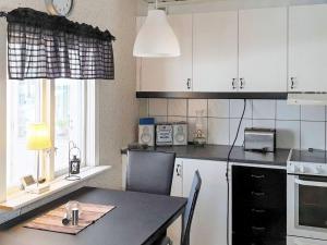 uma cozinha com armários brancos, uma mesa e uma janela em Holiday home BOLLNÄS em Bollnäs
