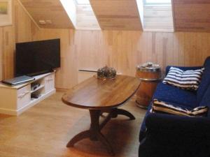 un soggiorno con tavolo in legno e TV di Four-Bedroom Holiday home in Gurskøy 1 a Kjellsund