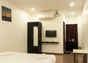 a bedroom with a bed and a tv on the wall at COSY CHAMBRE in Pondicherry