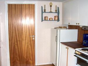a kitchen with a wooden door and a refrigerator at 5 person holiday home in MELLBYSTRAND in Mellbystrand