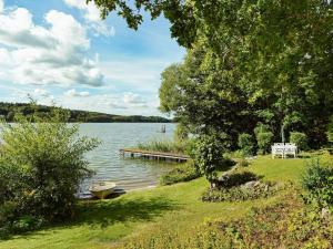 - une vue sur un lac avec un quai et des arbres dans l'établissement 5 person holiday home in MARIEFRED, à Mariefred
