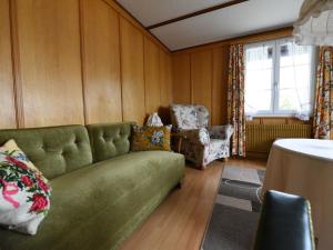 sala de estar con sofá verde y 2 sillas en Attractive holiday home with a beautiful view en Trans